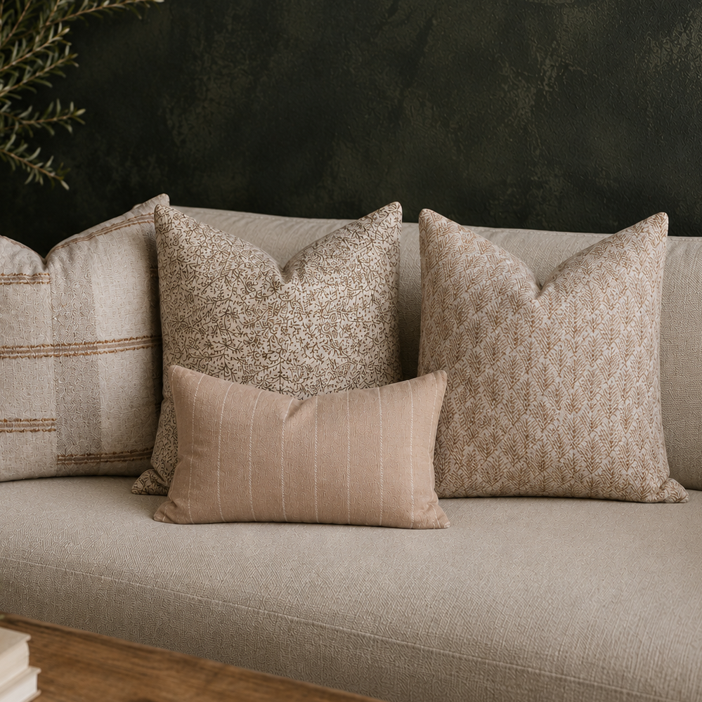 Beige sofa with patterned cushions against a dark wall