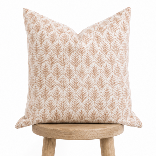 Decorative pillow with a geometric pattern on a wooden stool against a white background